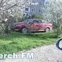 В Керчи иномарка паркуется на зеленом газоне под деревьями