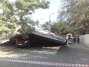 Крыша, сорванная ветром со здания ж/д вокзала в Феодосии, заблокировала автомобиль с пассажирами