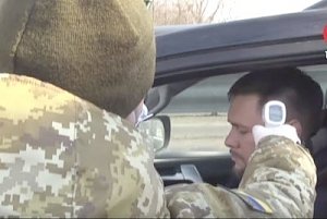 Украинские силовики измеряют температуру у людей, пересекающих границу российского Крыма с Херсонской областью